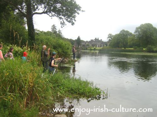 Fishing for salmon at the Cong river, County Mayo, Ireland- with Ashford Castle in the distance.