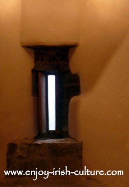 Loop window with shutter which was added later, at Annaghdown Castle, County Galway, Ireland.