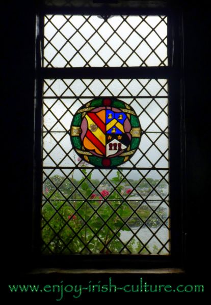 View out the window of the castle revealing a heraldic crest of the medieval owners.
