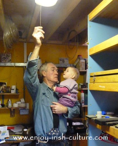 Irish piper and instrument maker Eugene Lambe switching off the light in his workshop after a days' work is done.